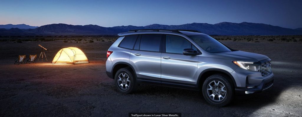 Night time in a camping zone next to a 2022 Honda Passport in Lunar Silver Metallic